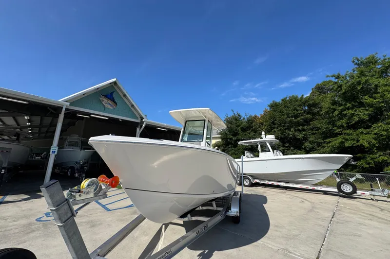 Slide: The Image of 2026 Sailfish 232 CC boat on trailer at dealership under clear blue sky. - 4