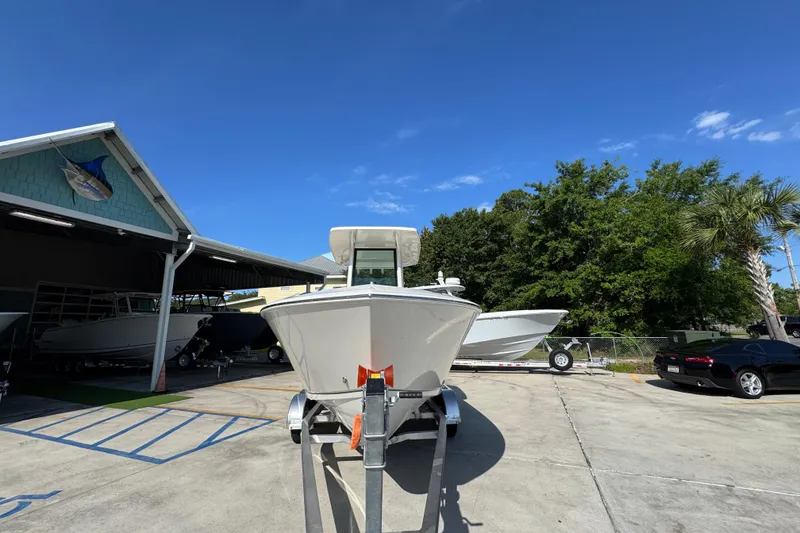 Slide: The Image of 2026 Sailfish 232 CC boat on trailer at dealership under clear blue sky. - 5
