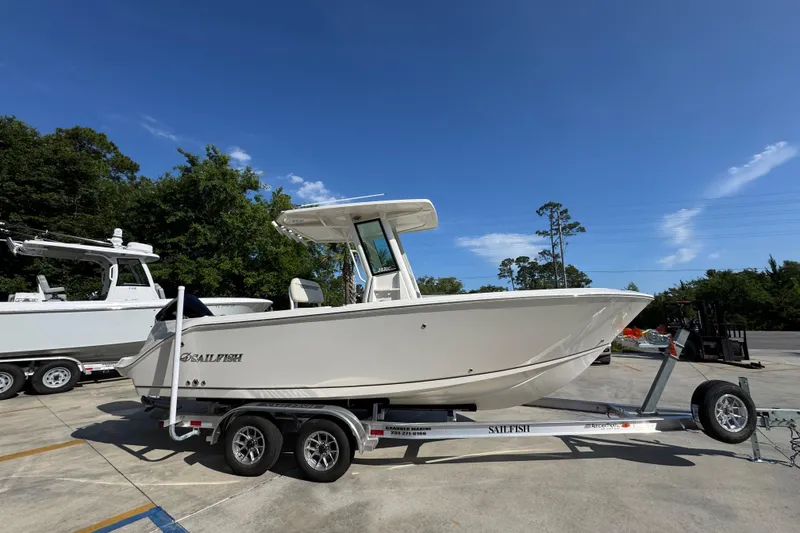Slide: The Image of 2026 Sailfish 232 CC boat on trailer, parked outdoors under clear blue sky. - 8