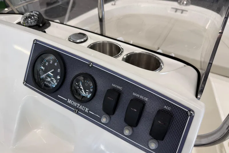Slide: The Image of 2021 Boston Whaler 150 Montauk dashboard with gauges and switches. - 12