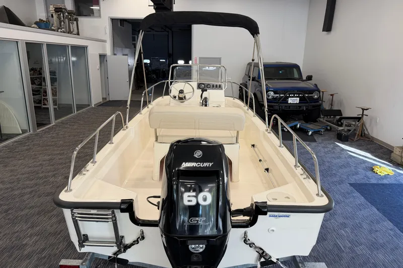 Slide: The Image of 2021 Boston Whaler 150 Montauk boat with Mercury 60 GT engine in showroom. - 3