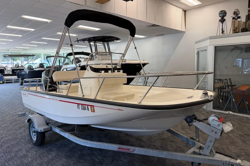 Slide: The Image of 2021 Boston Whaler 150 Montauk boat displayed indoors on a trailer. - 7
