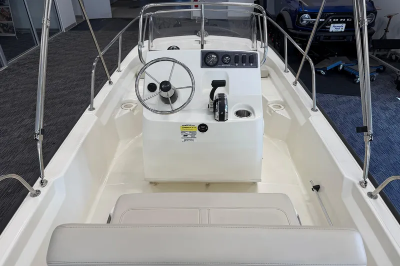 Slide: The Image of 2021 Boston Whaler 150 Montauk boat interior with steering console and seating. - 8