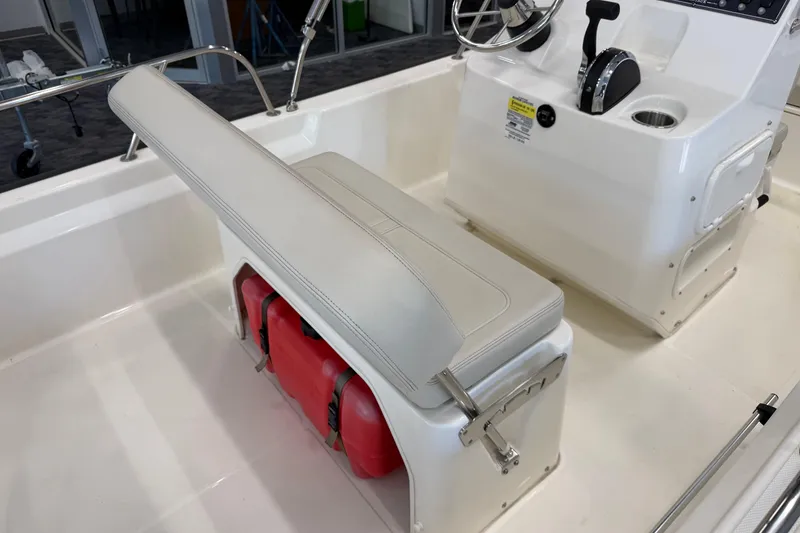 Slide: The Image of 2021 Boston Whaler 150 Montauk interior with seating and console, showcasing modern design. - 9