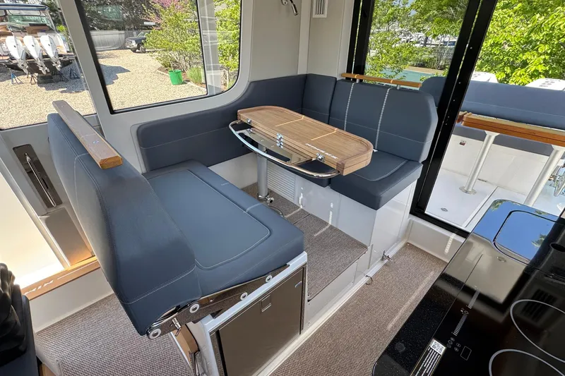 Slide: The Image of Interior of Nimbus Commuter 11 boat, 2025, featuring blue seating and wooden table. - 15