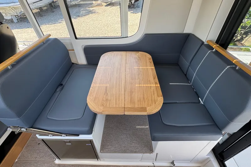 Slide: The Image of Interior of Nimbus Commuter 11, 2025, featuring blue seats and wooden table. - 19