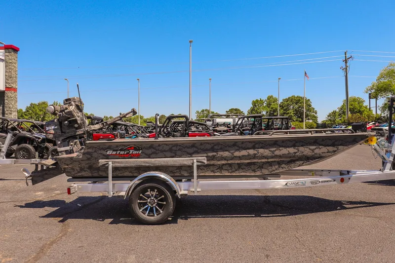 Slide: The Image of 2026 Gator Tail 17/50 MID DECK SAVAGE SERIES boat on trailer, parked outdoors. - 2