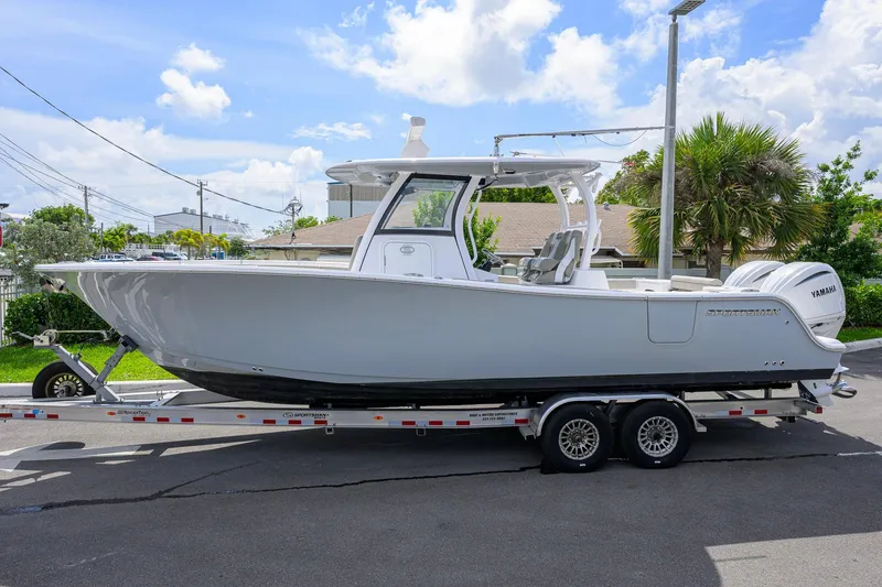 The Image of 2023 Sportsman Open 302 Center Console boat on trailer, parked outdoors. - 0