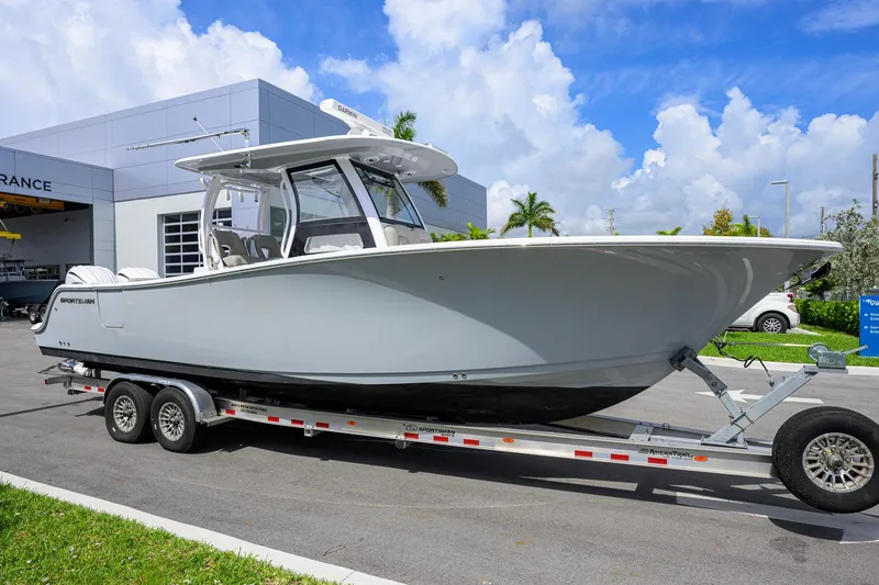 The Image of 2023 Sportsman Open 302 Center Console boat on trailer, parked outdoors. - 1