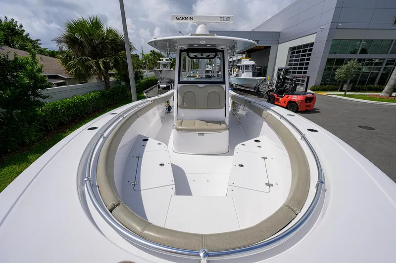 Slide: The Image of 2023 Sportsman Open 302 Center Console boat at a marina, showcasing spacious deck and seating. - 13