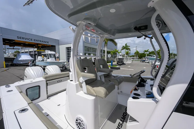 Slide: The Image of 2023 Sportsman Open 302 Center Console boat at service entrance, showcasing helm and seating area. - 16