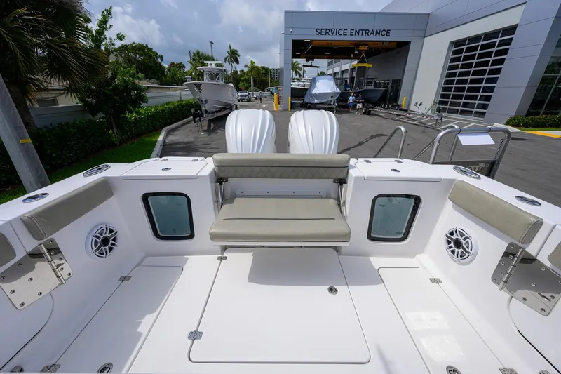 Slide: The Image of 2023 Sportsman Open 302 Center Console boat at service entrance, showcasing seating and deck layout. - 19