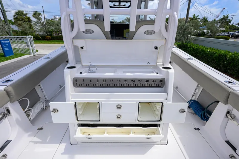 Slide: The Image of 2023 Sportsman Open 302 Center Console with storage compartments and measuring board. - 23