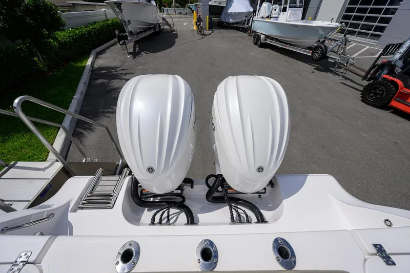 Slide: The Image of 2023 Sportsman Open 302 Center Console with dual outboard engines in a marina setting. - 37