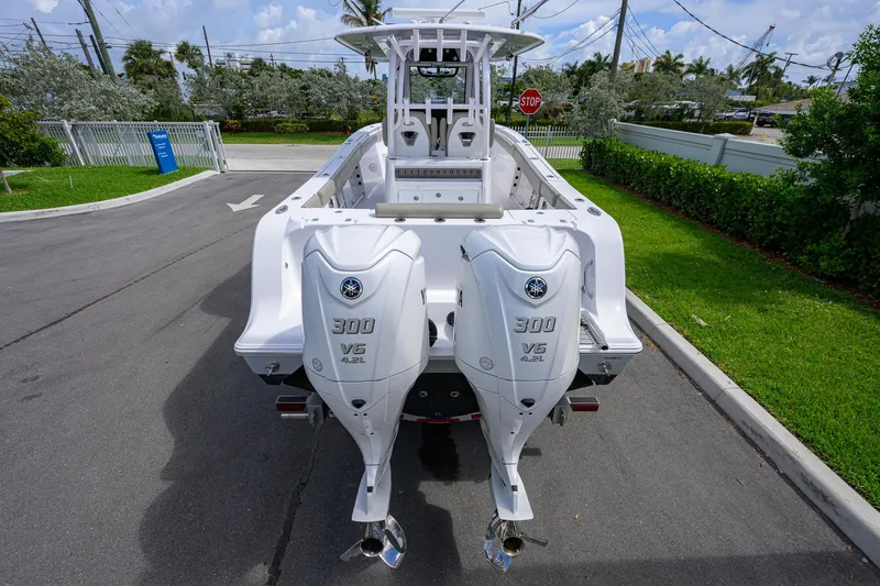 Slide: The Image of 2023 Sportsman Open 302 Center Console with twin Yamaha 300 V6 engines, parked outdoors. - 4