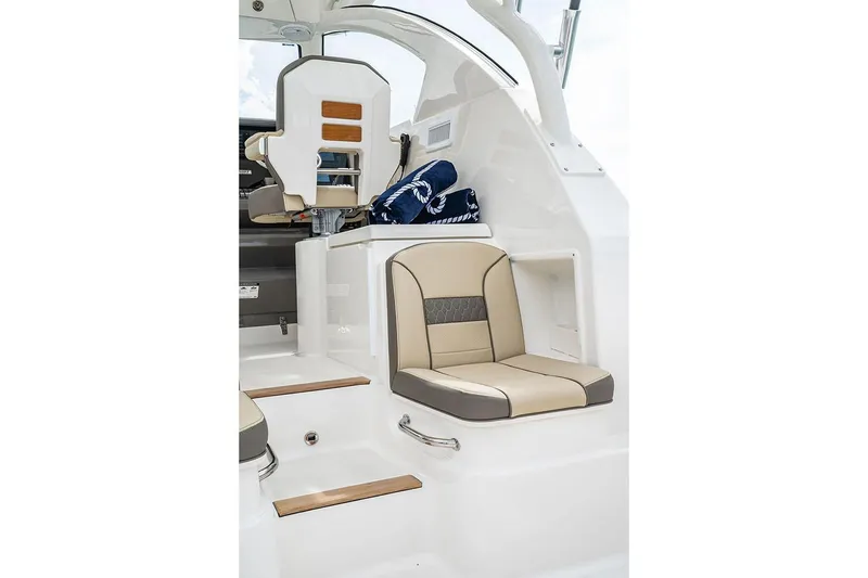 Slide: The Image of Manufacturer Provided Image: Interior seating of 2025 Pursuit OS 355 Offshore boat, featuring beige and gray upholstery. - 11