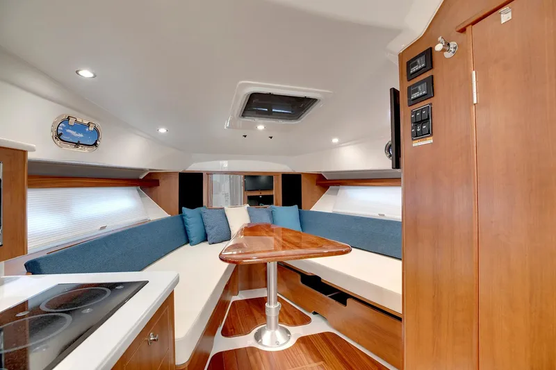 Slide: The Image of Manufacturer Provided Image: 2025 Pursuit OS 355 Offshore cabin interior with modern seating and wooden finishes. - 14