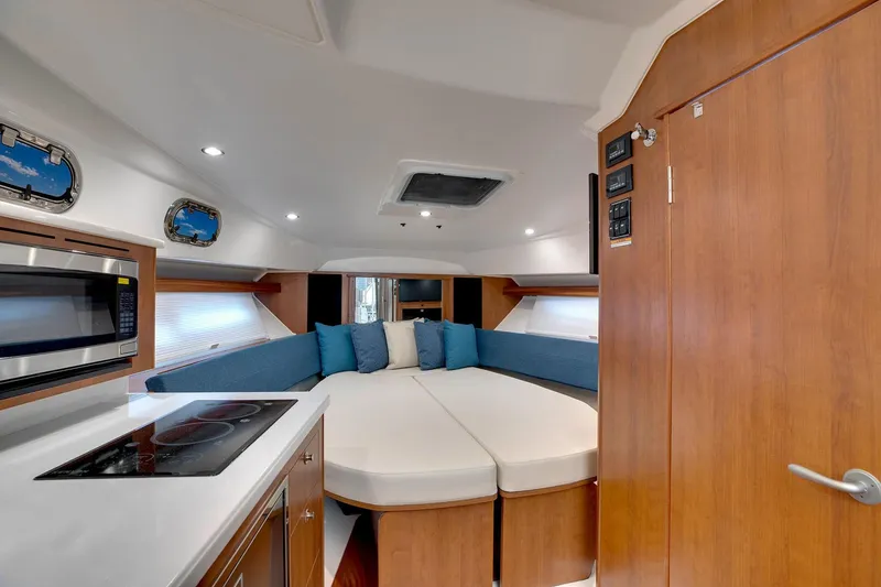 Slide: The Image of Manufacturer Provided Image: 2025 Pursuit OS 355 Offshore cabin interior with modern kitchen and cozy seating area. - 16