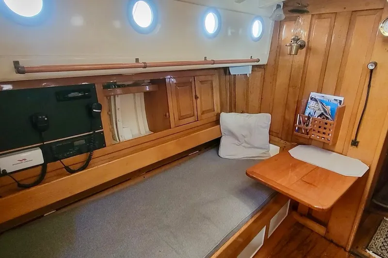 Slide: The Image of Cozy 1936 Freeman 37 boat cabin with wooden interior, portholes, and a cushioned bench. - 12