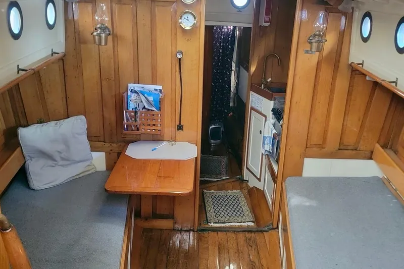 Slide: The Image of Interior of a 1936 Freeman 37 boat with wooden paneling and cozy seating. - 16