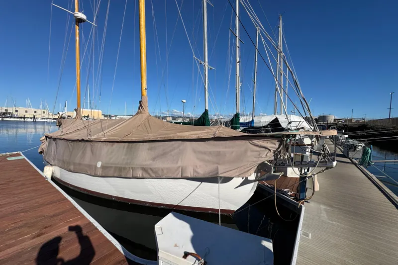 Slide: The Image of Vintage 1936 Freeman 37 sailboat docked, covered with a tarp, under clear blue skies. - 3