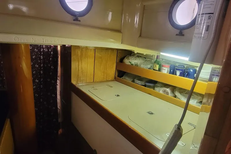 Slide: The Image of Interior of a 1936 Freeman 37 boat with wooden shelves and portholes. - 7