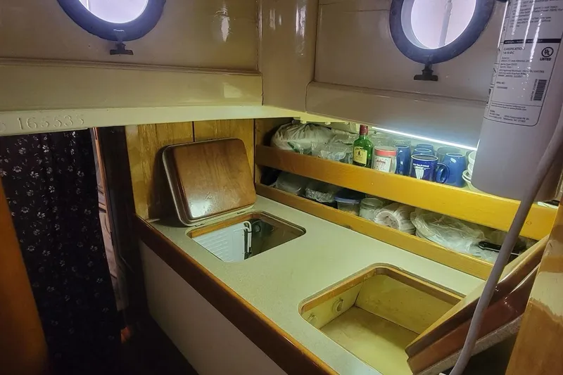 Slide: The Image of Vintage 1936 Freeman 37 boat kitchen with portholes, wooden cabinetry, and countertop storage. - 8