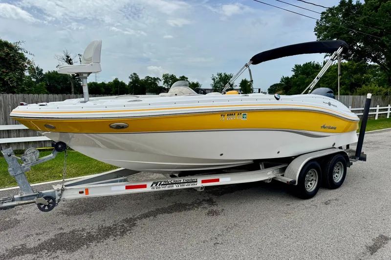 The Image of 2014 Hurricane SunDeck Sport 203 OB boat on trailer, yellow and white design. - 1