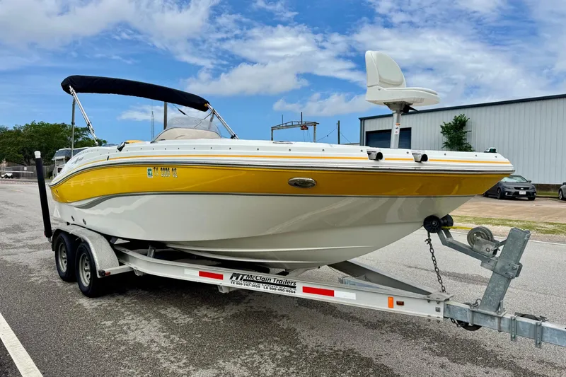 Slide: The Image of 2014 Hurricane SunDeck Sport 203 OB boat on trailer, yellow and white design, parked outdoors. - 5
