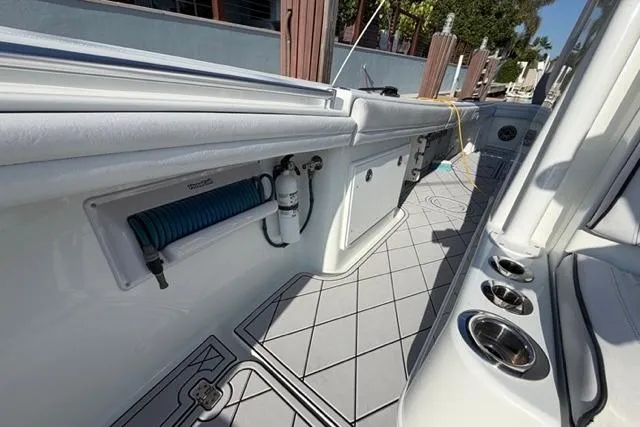 Slide: The Image of 2019 Yellowfin 32 Offshore boat deck with storage compartments and fishing rod holders. - 10