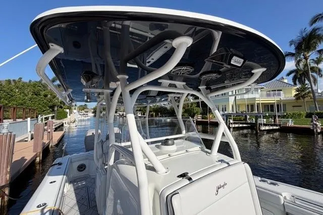 Slide: The Image of 2019 Yellowfin 32 Offshore boat docked by a canal under clear blue skies. - 12