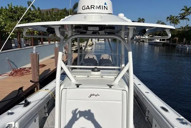 Slide: The Image of 2019 Yellowfin 32 Offshore boat docked, featuring Garmin equipment, surrounded by water and greenery. - 14