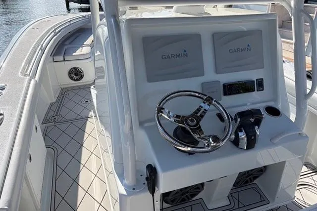 Slide: The Image of 2019 Yellowfin 32 Offshore boat cockpit with Garmin navigation system and sleek steering wheel. - 16