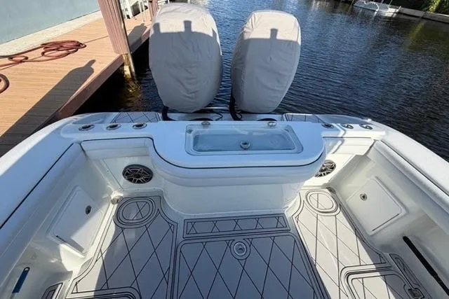 Slide: The Image of 2019 Yellowfin 32 Offshore boat deck with seating and storage, docked by the water. - 17