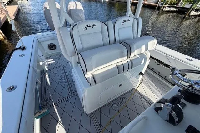 Slide: The Image of 2019 Yellowfin 32 Offshore boat interior with cushioned seating and steering wheel. - 18