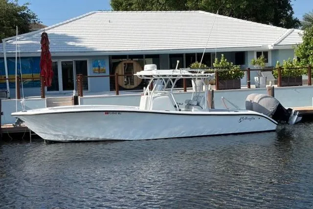 Slide: The Image of 2019 Yellowfin 32 Offshore boat docked by a waterfront house. - 2