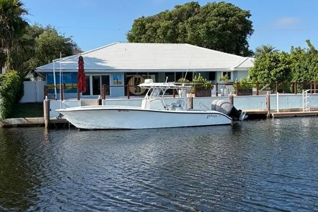 Slide: The Image of 2019 Yellowfin 32 Offshore boat docked by a waterfront house. - 3