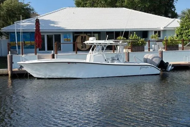 Slide: The Image of 2019 Yellowfin 32 Offshore boat docked by a waterfront house. - 4