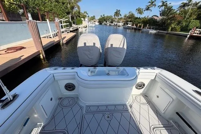 Slide: The Image of 2019 Yellowfin 32 Offshore boat docked in a scenic canal with lush greenery. - 5
