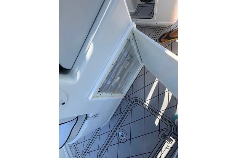 Slide: The Image of 2019 Yellowfin 32 Offshore boat interior with open storage compartment and patterned flooring. - 7