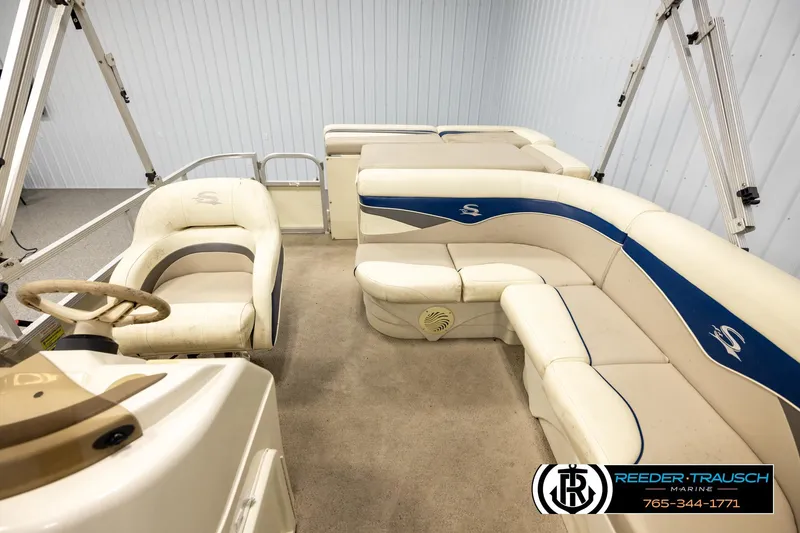 Slide: The Image of 2008 Sedona 20 CR boat interior with beige and blue seating, steering wheel, and carpeted floor. - 14