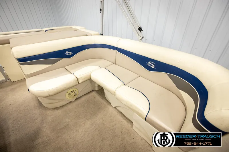 Slide: The Image of 2008 Sedona 20 CR boat interior with white and blue seating in a showroom. - 20