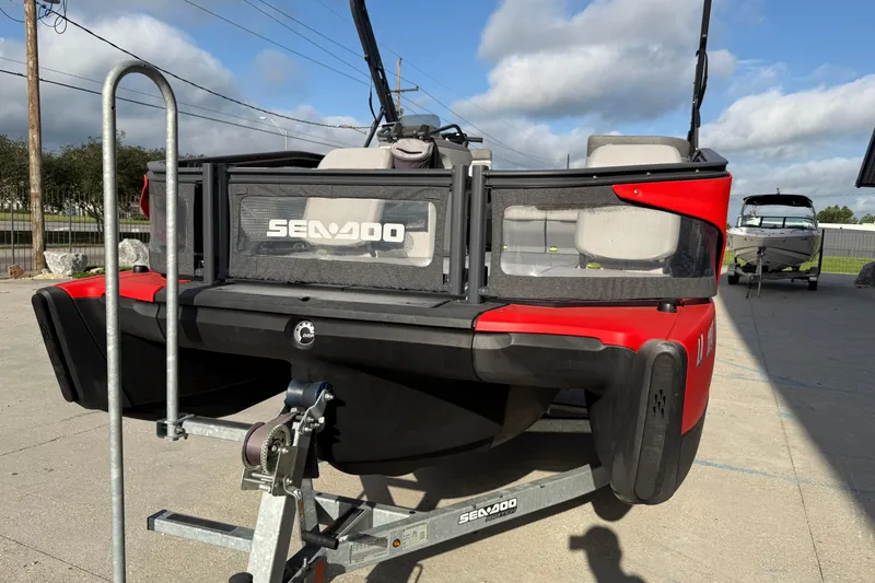 Slide: The Image of 2023 Sea-Doo Switch Sport 18 on trailer, red and black design, outdoor setting. - 10