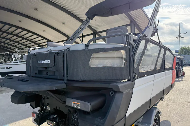 Slide: The Image of 2023 Sea-Doo Switch Sport 18 pontoon boat with canopy, parked in a marina. - 4
