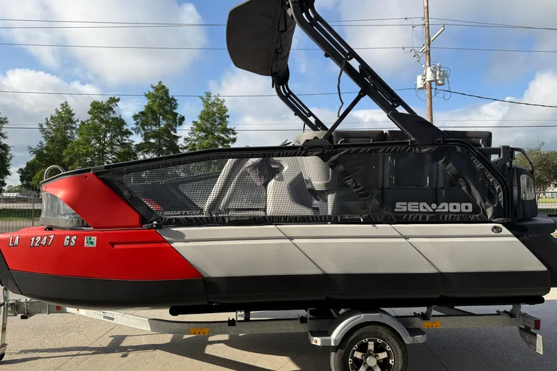 Slide: The Image of 2023 Sea-Doo Switch Sport 18 on trailer, red and gray design, parked outdoors. - 5