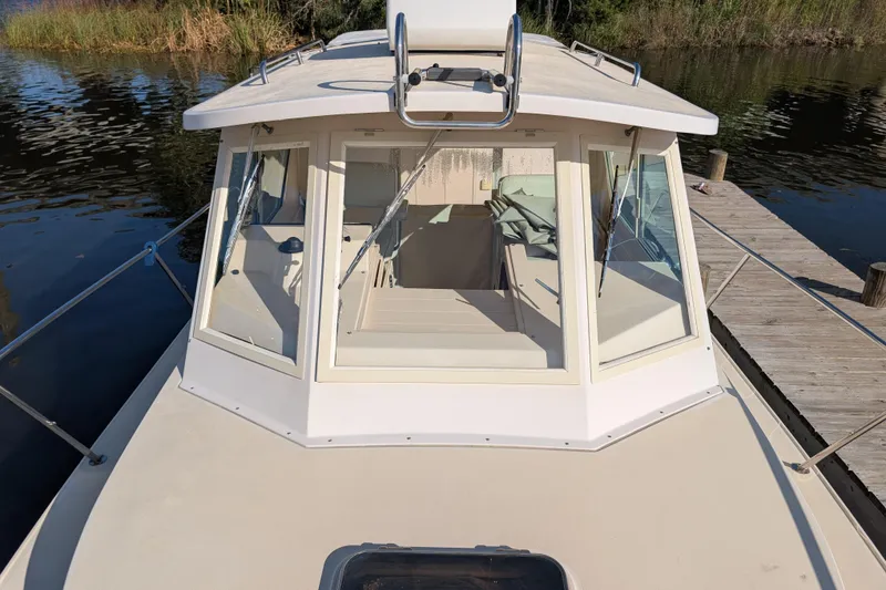 Slide: The Image of 2004 Albin 30 Family Cruiser docked by a serene lake. - 31