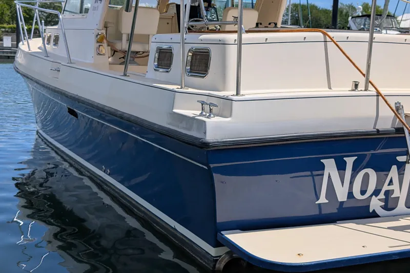 Slide: The Image of 2004 Albin 30 Family Cruiser docked, featuring a sleek blue and white design. - 43
