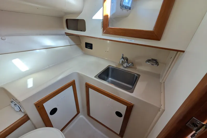 Slide: The Image of 2004 Albin 30 Family Cruiser bathroom with sink, mirror, and storage cabinets. - 8