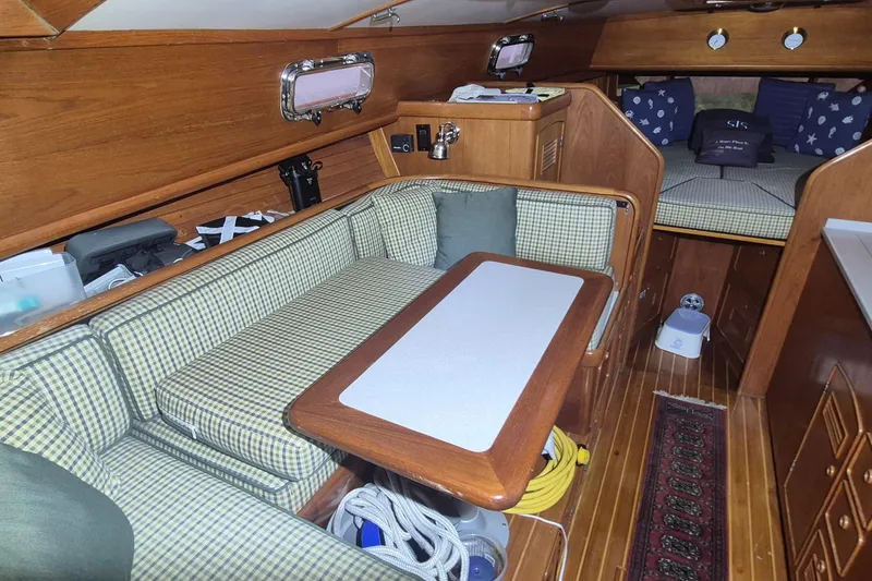Slide: The Image of 1990 Little Harbor Express yacht interior with wood finish, checkered seating, and cozy cabin space. - 13
