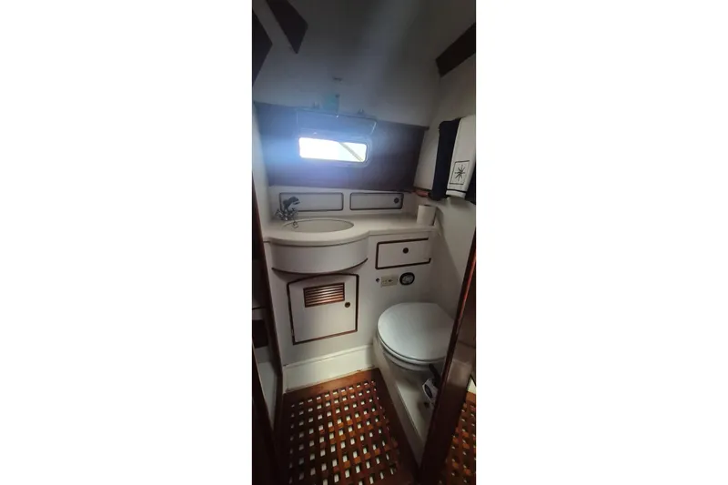 Slide: The Image of 1990 Little Harbor Express yacht bathroom with sink, toilet, and wooden flooring. - 21